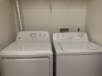 a laundry room with two washes and a dryer at Windsor Place, Davison, MI, 48423